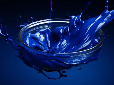 Blue Liquid Spills From Glass Into Blue Bowl