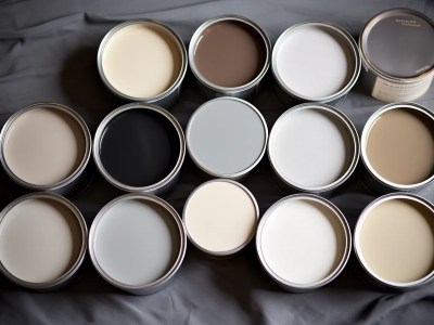 Multiple Cans Of Paint And A Dark Gray Fabric