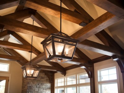 Two Light Fixtures Hanging In The Ceiling Of A Home With Wood Beams